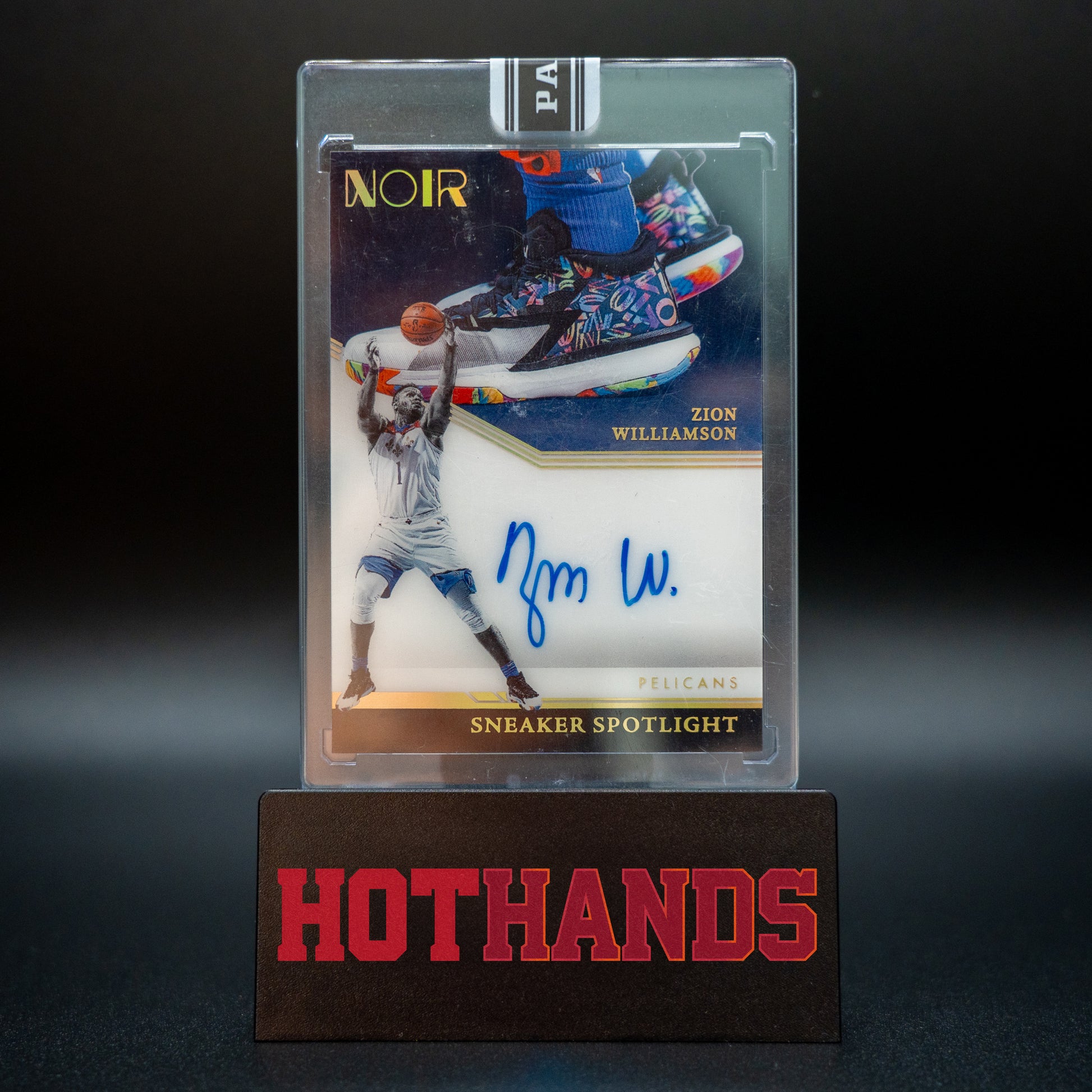 Zion Williamson Panini Noir Black Box 1/1 Sneaker Spotlight autographed card displayed on a Hot Hands stand.