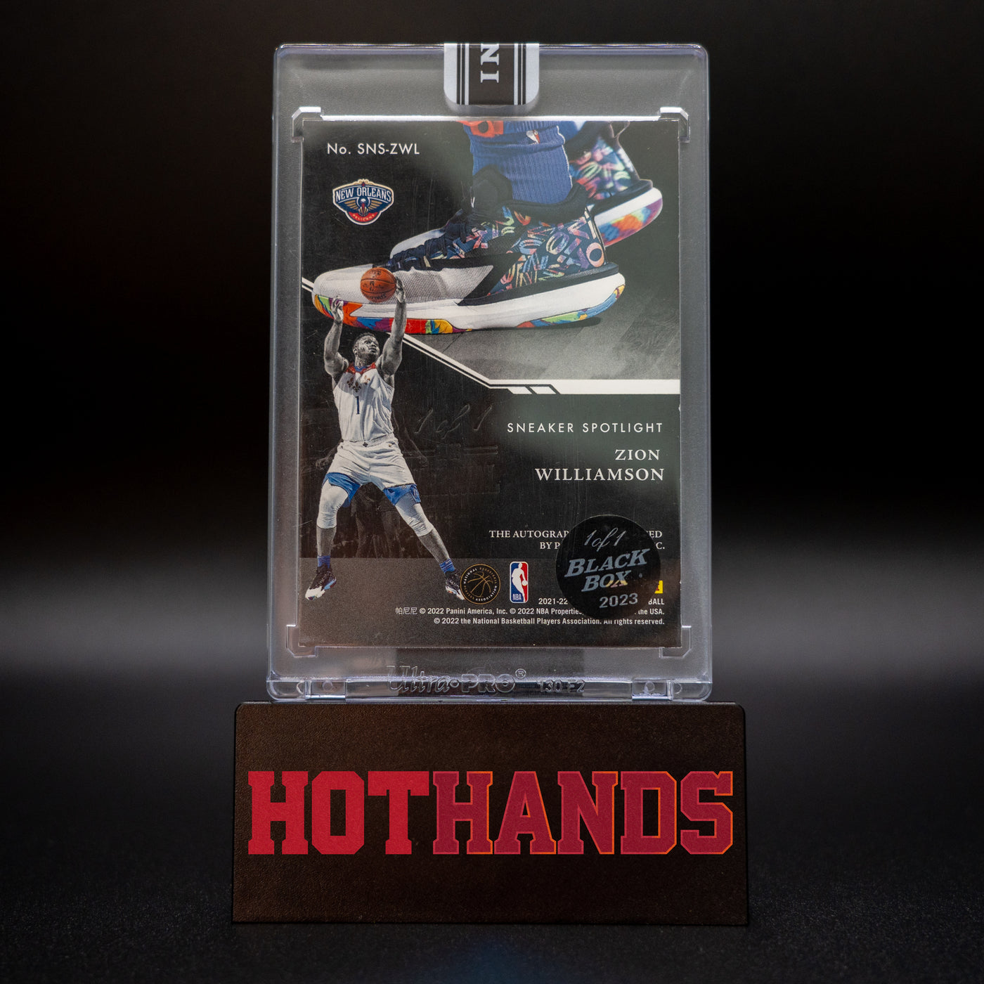 Back of the Zion Williamson Panini Noir Sneaker Spotlight card displayed on a Hot Hands stand, showing details of the card and 1/1 Black Box 2023 sticker.