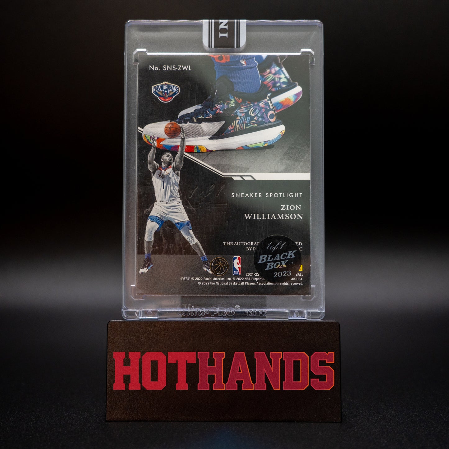 Back of the Zion Williamson Panini Noir Sneaker Spotlight card displayed on a Hot Hands stand, showing details of the card and 1/1 Black Box 2023 sticker.